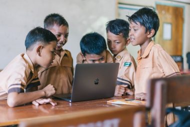 boy using silver macbook indoors